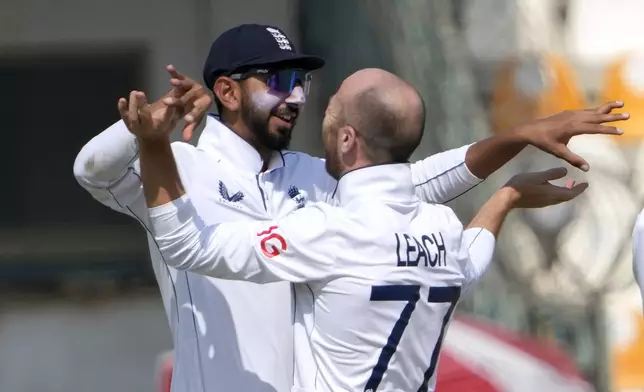 England's Jack Leach, right, celebrates with teammates Shoaib Bashir after taking the wicket of Pakistan's Kamran Ghulam during the third day of the second test cricket match between Pakistan and England, in Multan, Pakistan, Thursday, Oct. 17, 2024. (AP Photo/K.M. Chaudary)