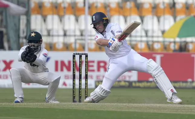 England's Ollie Pope, right, follows the ball after playing shot as Pakistan's Mohammad Rizwan watches during the second day of the second test cricket match between Pakistan and England, in Multan, Pakistan, Wednesday, Oct. 16, 2024. (AP Photo/K.M. Chaudary)