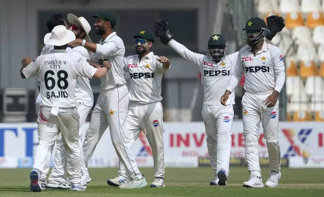 Pakistan's Shan Masood, fourth left, and teammates celebrates after winning the second test cricket match against England, in Multan, Pakistan, Friday, Oct. 18, 2024. (AP Photo/K.M. Chaudary)