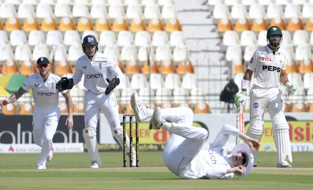 Pakistan's Shan Masood, right, looks to England's Zak Crawley, center, who taking his catch during the first day of the second test cricket match between Pakistan and England, in Multan, Pakistan, Tuesday, Oct. 15, 2024. (AP Photo/K.M. Chaudary)