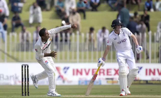 Pakistan's Noman Ali, left, bowls as England's Harry Brook watches during the day one of third test cricket match between Pakistan and England, in Rawalpindi, Pakistan, Thursday, Oct. 24, 2024. (AP Photo/Anjum Naveed)