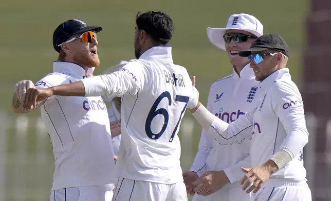 England's Shoaib Bashir, center, celebrates with teammates after taking the wicket of Pakistan's Shan Masood during the day two of third test cricket match between Pakistan and England, in Rawalpindi, Pakistan, Friday, Oct. 25, 2024. (AP Photo/Anjum Naveed)