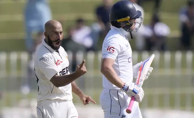 Pakistan's Sajid Khan, left, celebrates after taking the wicket of England's Ollie Pope, right, during the day one of third test cricket match between Pakistan and England, in Rawalpindi, Pakistan, Thursday, Oct. 24, 2024. (AP Photo/Anjum Naveed)