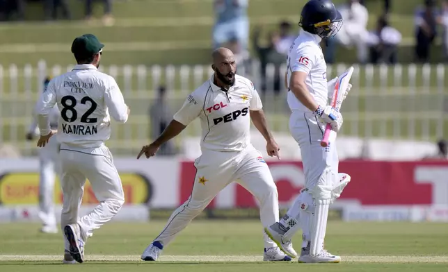 Pakistan's Sajid Khan, center, celebrates after taking the wicket of England's Ollie Pope, right, during the day one of third test cricket match between Pakistan and England, in Rawalpindi, Pakistan, Thursday, Oct. 24, 2024. (AP Photo/Anjum Naveed)