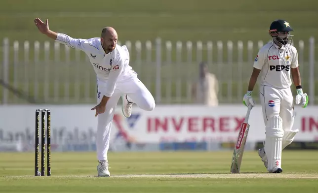 England's Jack Leach, left, bowls as Pakistan's Saud Shakeel watches during the day two of third test cricket match between Pakistan and England, in Rawalpindi, Pakistan, Friday, Oct. 25, 2024. (AP Photo/Anjum Naveed)