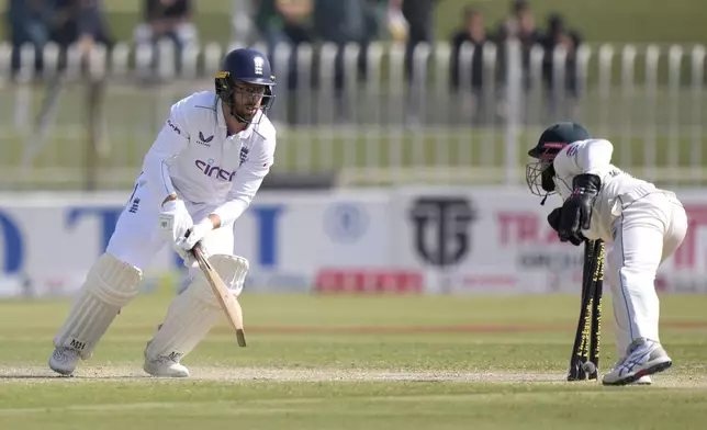 England's Jack Leach, left, looks back to wickets as he stump out by Pakistan's Mohammad Rizwan during the day three of third test cricket match between Pakistan and England, in Rawalpindi, Pakistan, Saturday, Oct. 26, 2024. (AP Photo/Anjum Naveed)