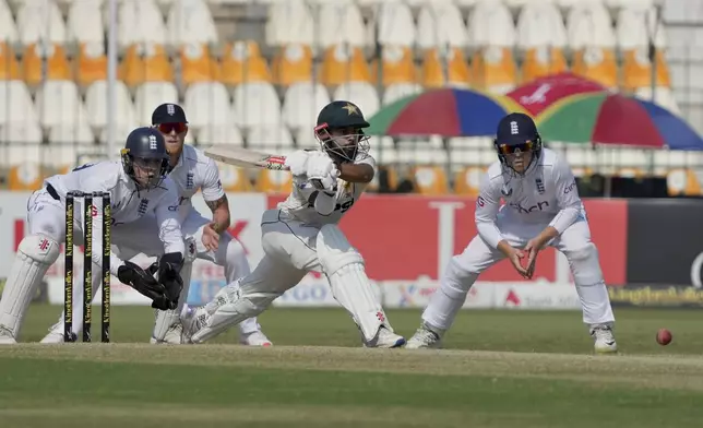 Pakistan's Saud Shakeel, center, plays a reverse sweep shot during the third day of the second test cricket match between Pakistan and England, in Multan, Pakistan, Thursday, Oct. 17, 2024. (AP Photo/K.M. Chaudary)