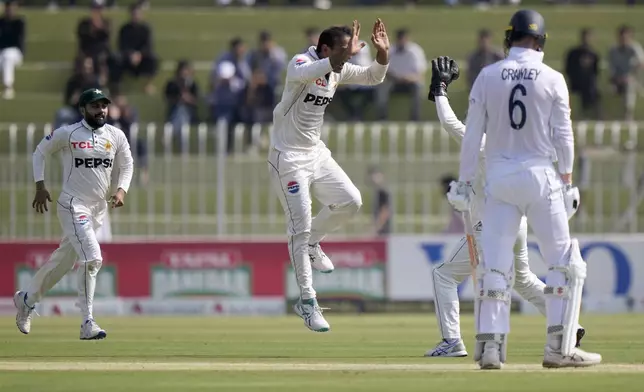 Pakistan's Noman Ali, center, celebrates with teammate after taking the wicket of England's Zak Crawley during the day one of third test cricket match between Pakistan and England, in Rawalpindi, Pakistan, Thursday, Oct. 24, 2024. (AP Photo/Anjum Naveed)