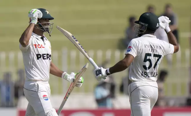 Pakistan's Shan Masood, left, and Pakistan's Abdullah Shafique celebrate after winning the third test cricket match against England, in Rawalpindi, Pakistan, Saturday, Oct. 26, 2024. (AP Photo/Anjum Naveed)