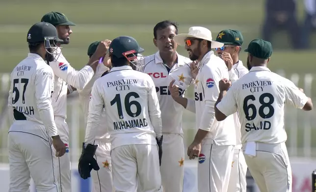 Pakistan's Noman Ali, center, celebrates with teammates after taking the wicket of England's Harry Brook during the day three of third test cricket match between Pakistan and England, in Rawalpindi, Pakistan, Saturday, Oct. 26, 2024. (AP Photo/Anjum Naveed)