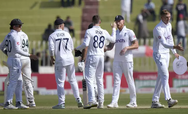 England's Ben Stokes, second right, and teammates shake hand on the end of third test cricket match against Pakistan, in Rawalpindi, Pakistan, Saturday, Oct. 26, 2024. (AP Photo/Anjum Naveed)