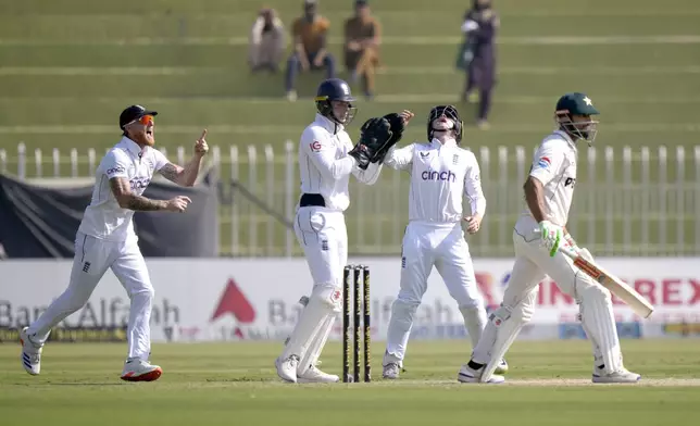 England's Ben Stokes, left, Jamie Smith, center, and Ollie Pope, second right, jubilate after the dismissal of Pakistan's Shan Masood, right, during the day two of third test cricket match between Pakistan and England, in Rawalpindi, Pakistan, Friday, Oct. 25, 2024. (AP Photo/Anjum Naveed)