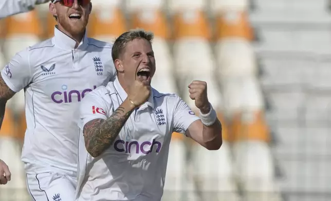 England's Brydon Carse, front, celebrates with teammates after taking the wicket of Pakistan's Saud Shakeel during the first day of the second test cricket match between Pakistan and England, in Multan, Pakistan, Tuesday, Oct. 15, 2024. (AP Photo/K.M. Chaudary)