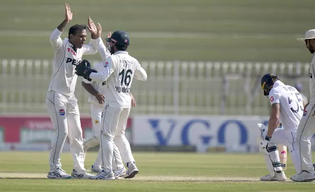 Pakistan's Noman Ali, left, celebrates with teammates after taking the wicket of England's Ben Stokes, second right, during the day three of third test cricket match between Pakistan and England, in Rawalpindi, Pakistan, Saturday, Oct. 26, 2024. (AP Photo/Anjum Naveed)