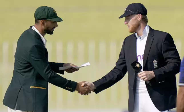 Pakistan's Shan Masood, left, shakes hand with his England counterpart Ben Stokes before the coin toss for the third test cricket match between Pakistan and England, in Rawalpindi, Pakistan, Thursday, Oct. 24, 2024. (AP Photo/Anjum Naveed)