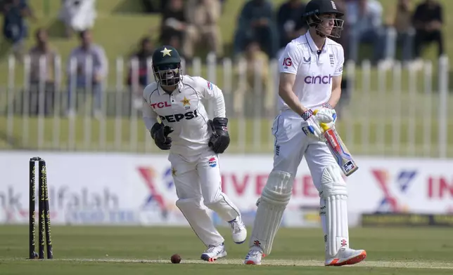 England's Harry Brook, right, reacts as Pakistan's Mohammad Rizwan celebrates his dismissal during the day one of third test cricket match between Pakistan and England, in Rawalpindi, Pakistan, Thursday, Oct. 24, 2024. (AP Photo/Anjum Naveed)