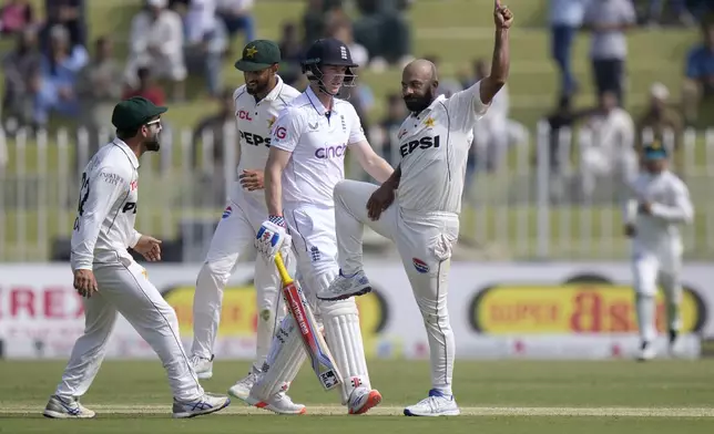 Pakistan's Sajid Khan, right, celebrates after taking the wicket of England's Harry Brook, center, during the day one of third test cricket match between Pakistan and England, in Rawalpindi, Pakistan, Thursday, Oct. 24, 2024. (AP Photo/Anjum Naveed)