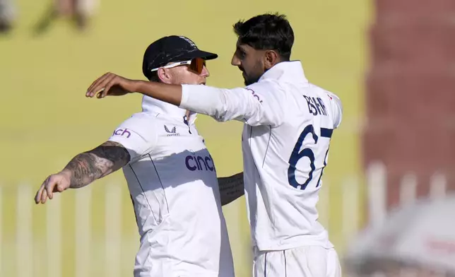 England's Shoaib Bashir, right, celebrates with teammate after taking the wicket of Pakistan's Noman Ali during the day two of third test cricket match between Pakistan and England, in Rawalpindi, Pakistan, Friday, Oct. 25, 2024. (AP Photo/Anjum Naveed)