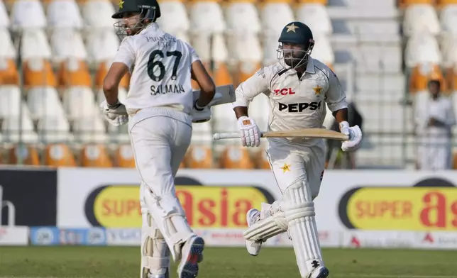 Pakistan's Sajid Khan, right, and Salman Ali Agha run between the wickets during the third day of the second test cricket match between Pakistan and England, in Multan, Pakistan, Thursday, Oct. 17, 2024. (AP Photo/K.M. Chaudary)