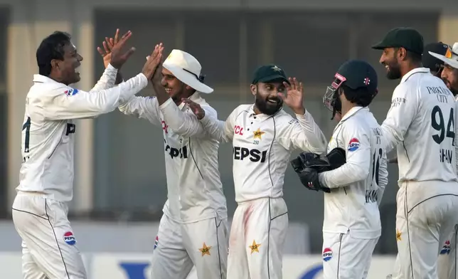 Pakistan's Noman Ali, left celebrates with teammates after taking the wicket of England's Ben Stokes during the second day of the second test cricket match between Pakistan and England, in Multan, Pakistan, Wednesday, Oct. 16, 2024. (AP Photo/K.M. Chaudary)