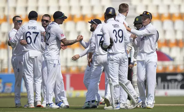 England's Ollie Pope, right, and teammates are congratulated each others after winning the first test cricket match against Pakistan, in Multan, Pakistan, Friday, Oct. 11, 2024. (AP Photo/Anjum Naveed)