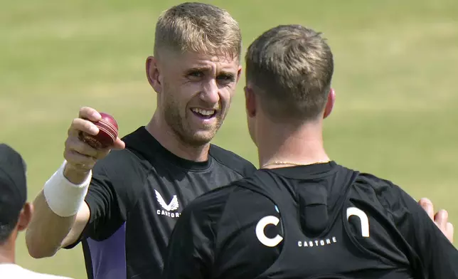 England's Olly Stone, left, briefs a bowling technique to Brydon Carse during a practice session, in Multan, Pakistan, Saturday, Oct. 5, 2024. (AP Photo/Anjum Naveed)