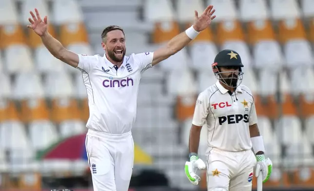 England's Chris Woakes, left, appeals successful LBW out of Pakistan's Babar Azam, right, during the first day of the first test cricket match between Pakistan and England, in Multan, Pakistan, Monday, Oct. 7, 2024. (AP Photo/Anjum Naveed)