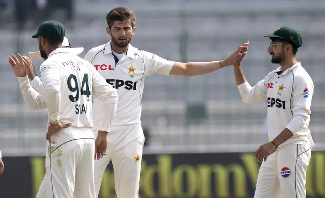 Pakistan's Shaheen Shah Afridi, center, celebrates with teammates after taking the wicket of England's Zak Crawley during the third day of the first test cricket match between Pakistan and England, in Multan, Pakistan, Wednesday, Oct. 9, 2024. (AP Photo/Anjum Naveed)