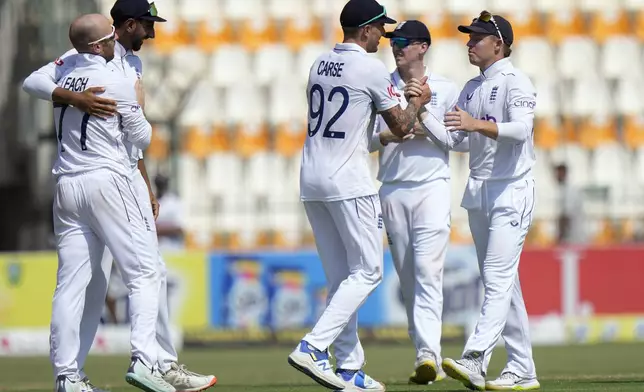 England's Ollie Pope, left, and teammates are congratulated each others after winning the first test cricket match against Pakistan, in Multan, Pakistan, Friday, Oct. 11, 2024. (AP Photo/Anjum Naveed)