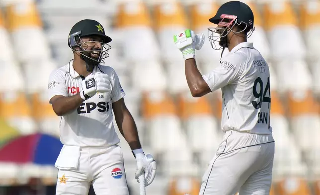 Pakistan's Abdullah Shafique, left, celebrates with teammate Shan Masood after scoring century during the first day of the first test cricket match between Pakistan and England, in Multan, Pakistan, Monday, Oct. 7, 2024. (AP Photo/Anjum Naveed)