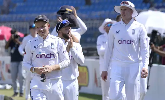 England's Ollie Pope, left, and teammates walk off the field after winning the first test cricket match against Pakistan, in Multan, Pakistan, Friday, Oct. 11, 2024. (AP Photo/Anjum Naveed)