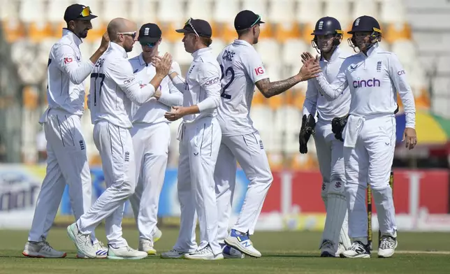 England's Ollie Pope, center, and teammates are congratulated each others after winning the first test cricket match against Pakistan, in Multan, Pakistan, Friday, Oct. 11, 2024. (AP Photo/Anjum Naveed)