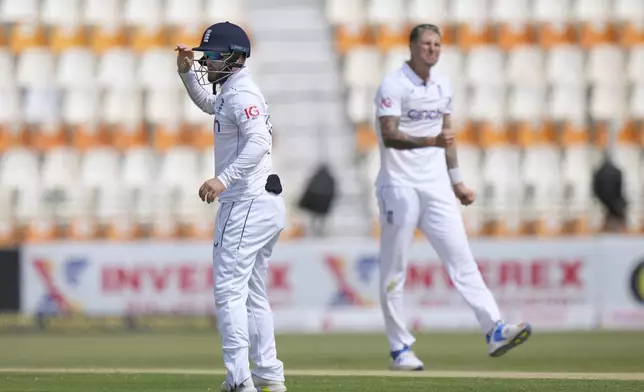 England's Ben Duckett, left, and Brydon Carse react when Duckett miss a catch opportunity during the second day of the first test cricket match between Pakistan and England, in Multan, Pakistan, Tuesday, Oct. 8, 2024. (AP Photo/Anjum Naveed)