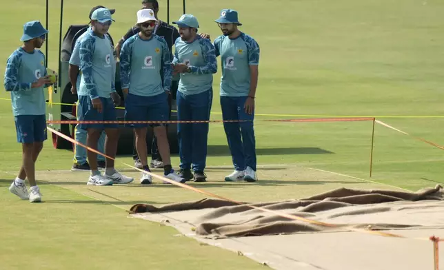 Pakistan's Sarfaraz Ahmed, second right, chats with teammates as they examine the pitch preparing for 1st test cricket match between England and Pakistan, before a practice session, in Multan, Pakistan, Sunday, Oct. 6, 2024. (AP Photo/Anjum Naveed)