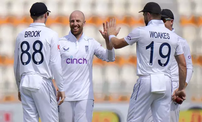 England's Jack Leach, center, celebrates with teammates after taking the wicket of Pakistan's Mohammad Rizwan during the second day of the first test cricket match between Pakistan and England, in Multan, Pakistan, Tuesday, Oct. 8, 2024. (AP Photo/Anjum Naveed)