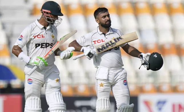 Pakistan's Abdullah Shafique, right, celebrates with teammate Shan Masood after scoring century during the first day of the first test cricket match between Pakistan and England, in Multan, Pakistan, Monday, Oct. 7, 2024. (AP Photo/Anjum Naveed)