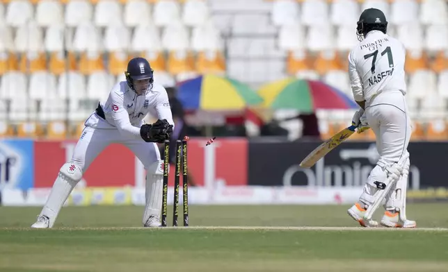 England's Jamie Smith, left, removes bails to stump out to Pakistan's Naseem Shah during the fifth day of the first test cricket match between Pakistan and England, in Multan, Pakistan, Friday, Oct. 11, 2024. (AP Photo/Anjum Naveed)