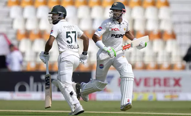 Pakistan's Abdullah Shafique, left, and Shan Masood run between the wickets during the first day of the first test cricket match between Pakistan and England, in Multan, Pakistan, Monday, Oct. 7, 2024. (AP Photo/Anjum Naveed)