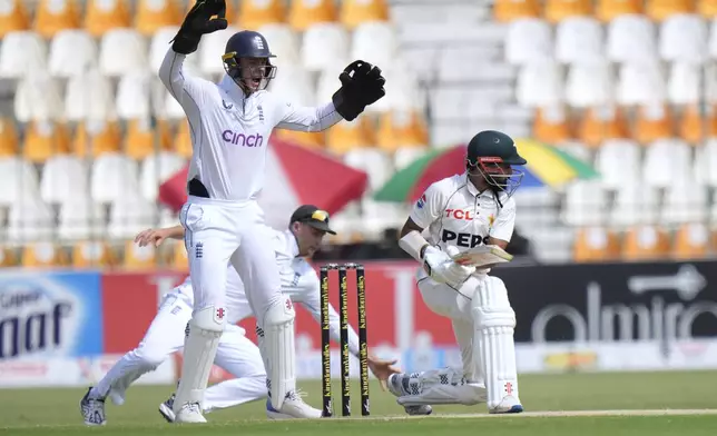 England's Jamie Smith, left, reacts when a close call of LBW out of Pakistan's Saud Shakeel, right, during the second day of the first test cricket match between Pakistan and England, in Multan, Pakistan, Tuesday, Oct. 8, 2024. (AP Photo/Anjum Naveed)