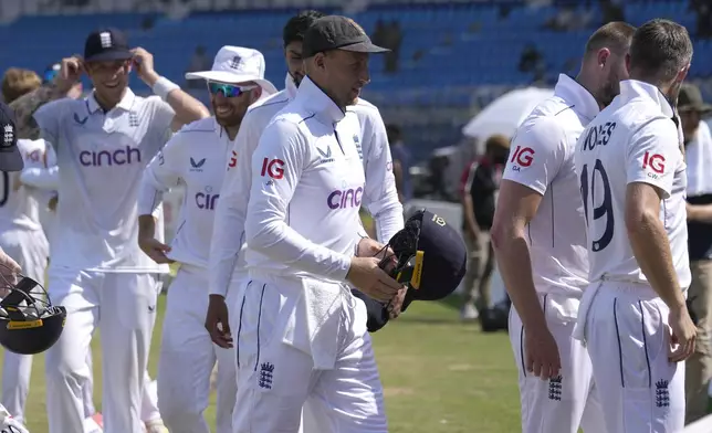 England's Joe Root, center, and teammates walk off the field after winning the first test cricket match against Pakistan, in Multan, Pakistan, Friday, Oct. 11, 2024. (AP Photo/Anjum Naveed)