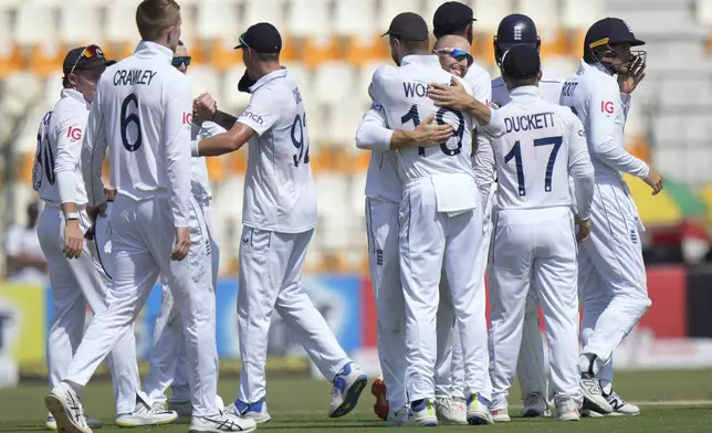 England's Jack Leach, center in glasses, and teammates are congratulated each others after winning the first test cricket match against Pakistan, in Multan, Pakistan, Friday, Oct. 11, 2024. (AP Photo/Anjum Naveed)