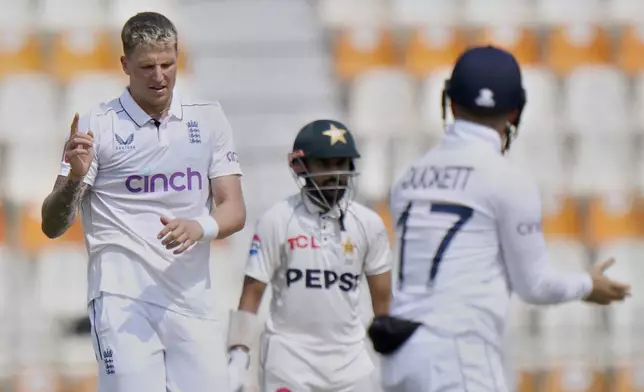 England's Brydon Carse, left, celebrates after taking the wicket of Pakistan's Naseem Shah during the second day of the first test cricket match between Pakistan and England, in Multan, Pakistan, Tuesday, Oct. 8, 2024. (AP Photo/Anjum Naveed)