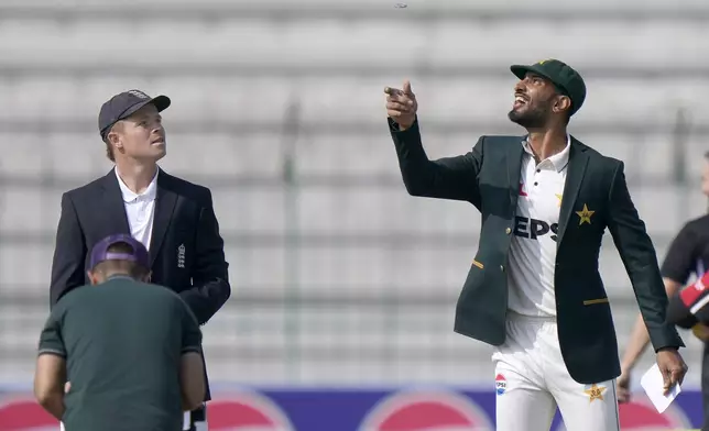 Pakistan's Shan Masood, right, flips the coin for toss as England's Ollie Pope, left, watches before the start of the play of first test cricket match between Pakistan and England, in Multan, Pakistan, Monday, Oct. 7, 2024. (AP Photo/Anjum Naveed)