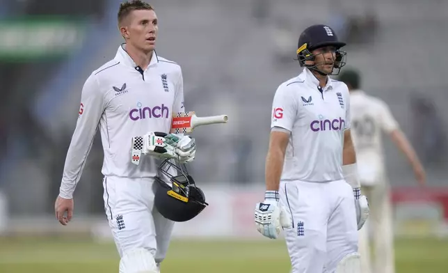 England's Zak Crawley, left, and and Joe Root walk off the field on the end of the second day game of the first test cricket match between Pakistan and England, in Multan, Pakistan, Tuesday, Oct. 8, 2024. (AP Photo/Anjum Naveed)