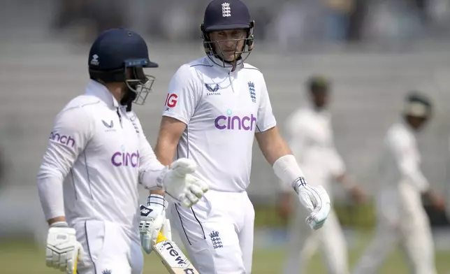 England's Joe Root, right, chat with Ben Duckett as they walk off the field on the lunch break during the third day of the first test cricket match between Pakistan and England, in Multan, Pakistan, Wednesday, Oct. 9, 2024. (AP Photo/Anjum Naveed)