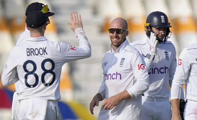 England's Jack Leach, center, celebrates with teammates after taking the wicket of Pakistan's Shan Masood during the first day of the first test cricket match between Pakistan and England, in Multan, Pakistan, Monday, Oct. 7, 2024. (AP Photo/Anjum Naveed)