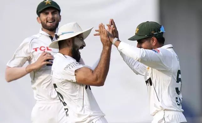 Pakistan's Aamer Jamal, center, celebrates with teammates after taking the catch of England's Ollie Pope during the second day of the first test cricket match between Pakistan and England, in Multan, Pakistan, Tuesday, Oct. 8, 2024. (AP Photo/Anjum Naveed)