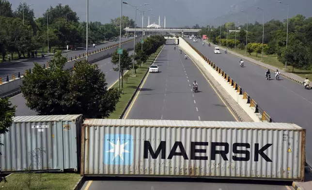 Shipping containers placed by authorities block a key highway to capital city in an attempt to prevent supporters of imprisoned former Prime Minister Imran Khan from holding a rally seeking his release in Islamabad, Pakistan, Friday, Oct. 4, 2024. (AP Photo/W.K. Yousafzai)