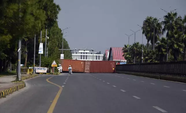 Shipping containers placed by authorities block a key highway to capital city in an attempt to prevent supporters of imprisoned former Prime Minister Imran Khan from holding a rally seeking his release in Islamabad, Pakistan, Friday, Oct. 4, 2024. (AP Photo/W.K. Yousafzai)