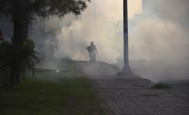 Police officers fire tear gas to disperse the supporters of imprisoned former Prime Minister Imran Khan's party Pakistan Tehreek-e-Insaf during a protest in Islamabad, Pakistan, Friday, Oct. 4, 2024.(AP Photo/W.K. Yousafzai)